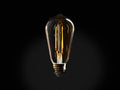 Amber glass LED ST19 bulb with E26 base, showing two-line filament glowing warmly. Black background accentuates bulb shape.