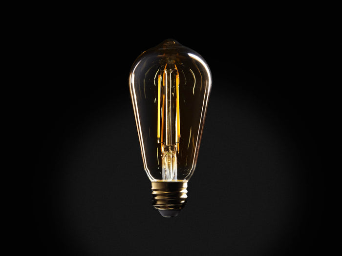 Amber glass LED ST19 bulb with E26 base, showing two-line filament glowing warmly. Black background accentuates bulb shape.