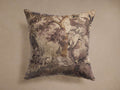 Square Lento Pillow with muted floral-botanical pattern in browns, beige, and purple, centered against a plain taupe background.