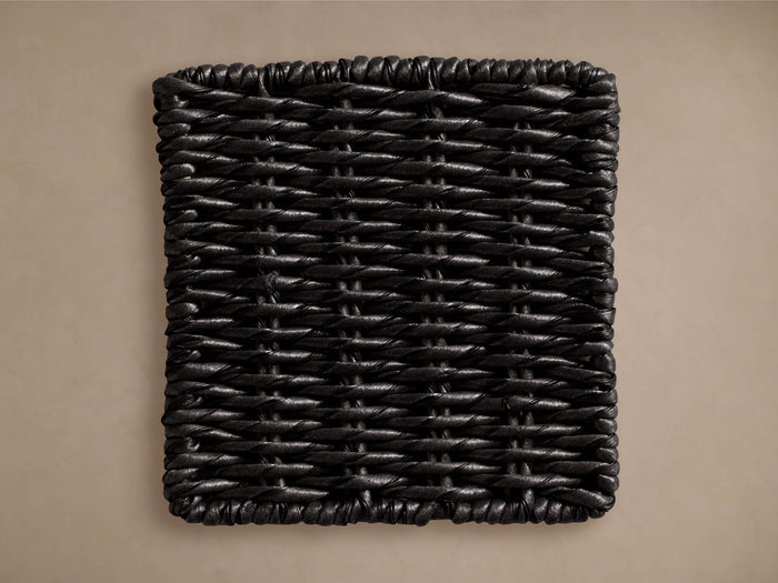Black, rectangular Leon Outdoor Finish Board with a tightly woven texture, shown against a muted brown background.