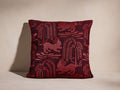 Leon Pillow; square burgundy pillow with lighter red woven pattern of stylized lions and weeping trees, facing forward.