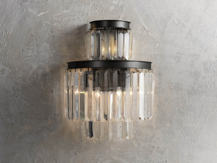 Leyland Sconce with multifaceted K9 glass crystals on an iron frame with oil-rubbed finish, mounted on a textured wall.