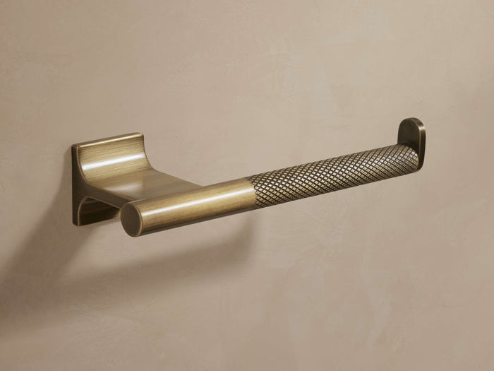 Liam Toilet Paper Holder in antique brass with knurled detailing; open-ended with an end stopper, mounted on a wall.