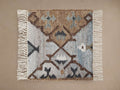 Square Lido Rug Swatch with textured weave in brown, light blue, dark grey geometric pattern and white fringe.