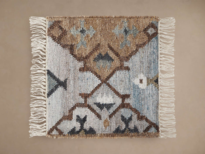 Square Lido Rug Swatch with textured weave in brown, light blue, dark grey geometric pattern and white fringe.