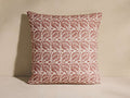 Lilith Pillow, square, with a repeating reddish-brown vintage-inspired floral and leaf pattern on a cream background, standing.