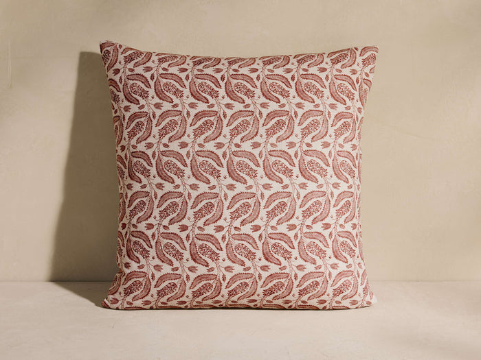 Lilith Pillow, square, with a repeating reddish-brown vintage-inspired floral and leaf pattern on a cream background, standing.