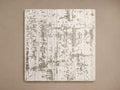 Madison Rug Swatch: rectangular fabric with an abstract, distressed pattern in off-white and brownish-grey, on a brown surface.
