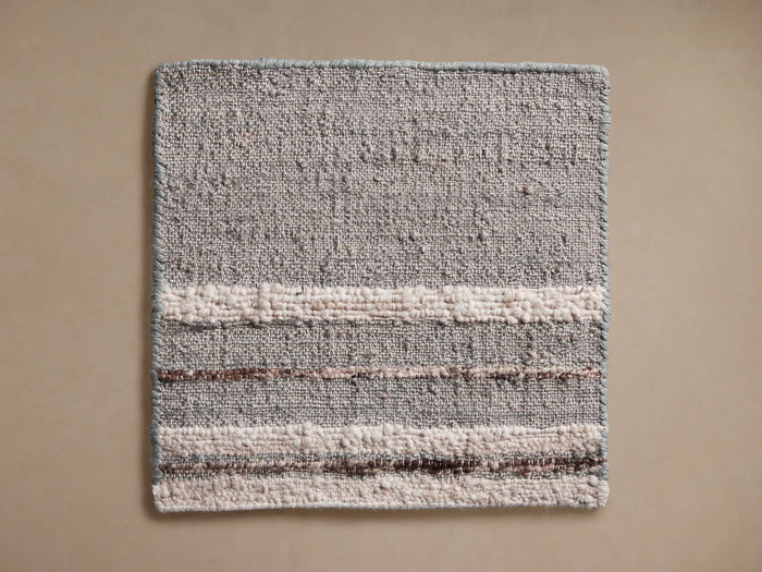 Maeve Rug Swatch: Square, textured light gray swatch with horizontal cream boucle and brown thread stripes.