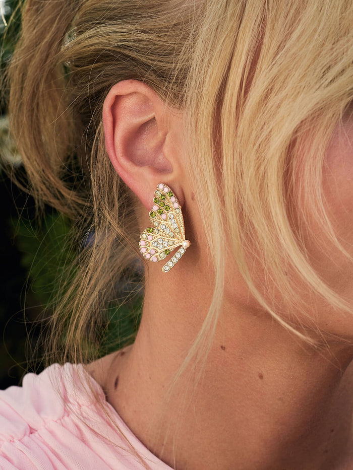 Close-up of a person wearing a decorative earring with a blurred background