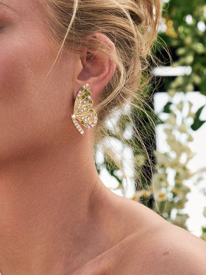 Close-up of a woman wearing a decorative earring with a blurred natural background