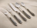 Marlene Five Piece Place Setting with shiny stainless steel tops and dark, hand-antiqued, fluted handles, arranged diagonally.