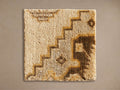 Maverick Hand-Knotted Rug Swatch, square, textured cream base with abstract brown and gold geometric patterns, laid flat.