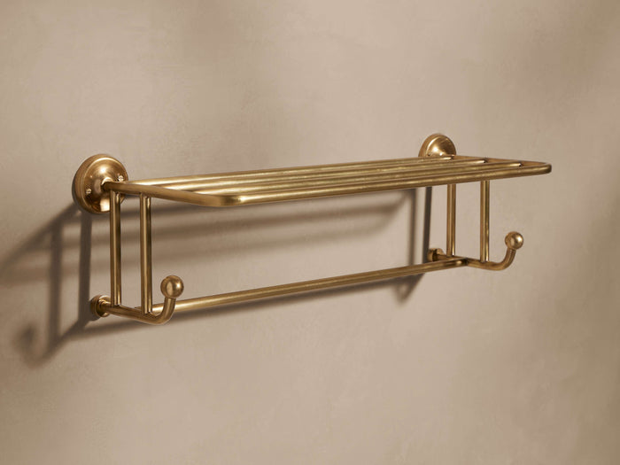 Maxwell Wall Rack, antiqued brass, wall-mounted with a slatted top shelf and a lower bar featuring two ball-end hooks.
