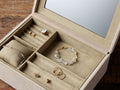Meline Suede Jewelry Box open, revealing a tan sectioned interior with a mirror in the lid and various jewelry pieces.