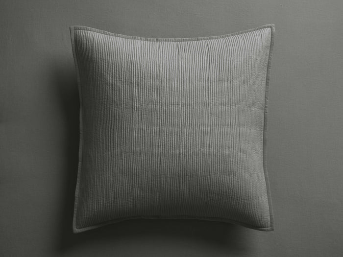 Light grey Mira Voile Sham with vertical machine stitching and hemmed edges, resting flat on a dark grey surface.