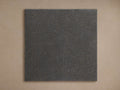 Martini Outdoor Finish Board. Square, dark grey textured finish board with small speckles, against a light brown background.
