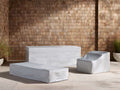Three light grey Montauk Outdoor Collection Covers on a patio: one for a sofa, one for a table, one for an armchair.