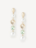 A pair of gold drop earrings featuring a gold oval stud, a white pearl, a gold scalloped shell charm, a round light green gemstone, and a dangling white pearl, shown on a light off-white background.