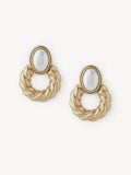 A pair of gold-toned twisted rope hoop earrings with oval white inlay stones, displayed on a clean off-white background.