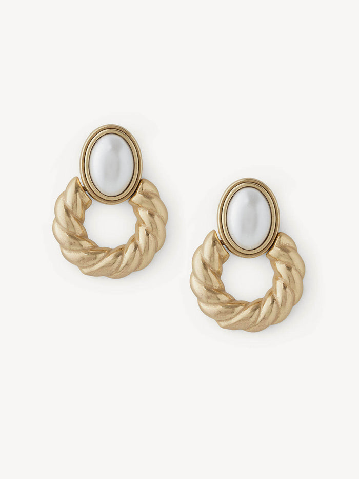 A pair of gold-toned twisted rope hoop earrings with oval white inlay stones, displayed on a clean off-white background.