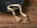 Neutral Strand featuring light-colored resin beads and jute rope, displayed on a wooden surface with a dark bowl.