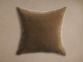 Square, soft brown mohair pillow with a subtle velvet-like sheen, centered on a light, warm neutral background.