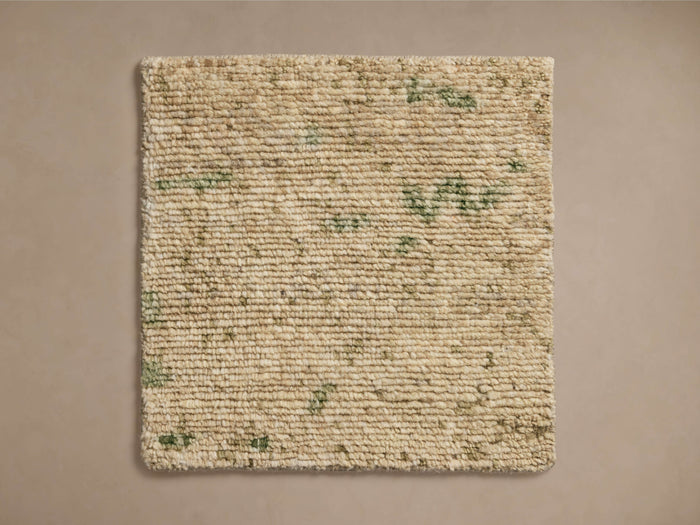 Nila Hand-Knotted Rug Swatch, beige surface with subtle green speckles, square-shaped, laid flat on a neutral background.