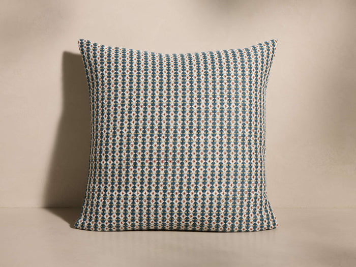 Front view of the Nootka Pillow, featuring a woven cream, teal, and rust geometric motif.