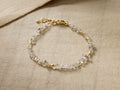 Oaklynn Bracelet with clear, raw Herkimer diamonds & small gold vermeil beads, delicate gold clasp, on light brown fabric.