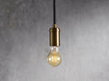 Ohlson Brass Swag Pendant with a brass-plated finish, hanging against a textured gray background.