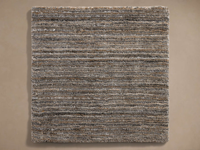 Top-down view of a rectangular rug with multi-toned, textured horizontal stripes in brown, gray, and off-white.