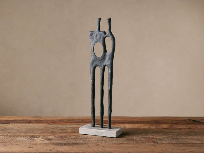Abstract Pair Sculpture: matte black aluminum figures, one with circular cutout, standing on a rectangular white marble base.