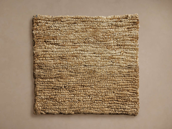 Pearce Rug Swatch, natural tan woven texture, rectangular shape, shown flat on a neutral taupe background.