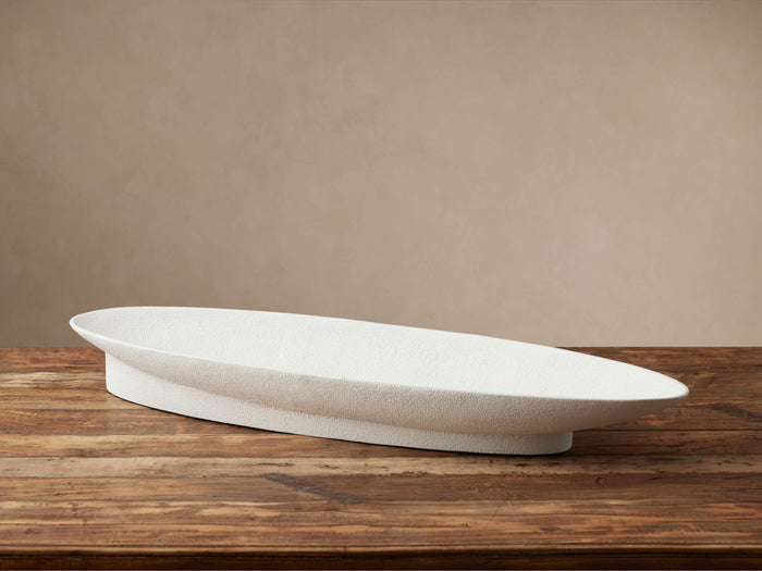 Planes Centerpiece Bowl: Elongated white stucco-finished bowl with textured surface, on a rustic wooden table.