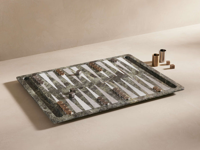 Rhodes Backgammon Set with marble board, brass and aluminum pieces. Includes four brass dice, displayed on a beige surface.