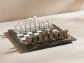 Rhodes Chess Set on a marble board featuring hand-carved white and brownish pieces, arranged for a game on a light surface.