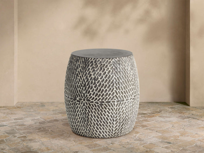Roche Outdoor End Table, barrel-shaped, dark gray top, hand-textured sides with light gray organic pattern on patio.