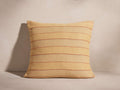 Rory Pillow: Square, light yellow textured pillow with slim reddish-brown horizontal stripes, standing on a neutral surface.