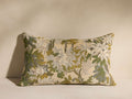 Sagamond Pillow: Rectangular pillow with a textured botanical pattern in forest green, grey, and cream, on a beige surface.