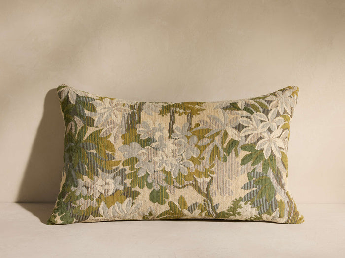 Sagamond Pillow: Rectangular pillow with a textured botanical pattern in forest green, grey, and cream, on a beige surface.