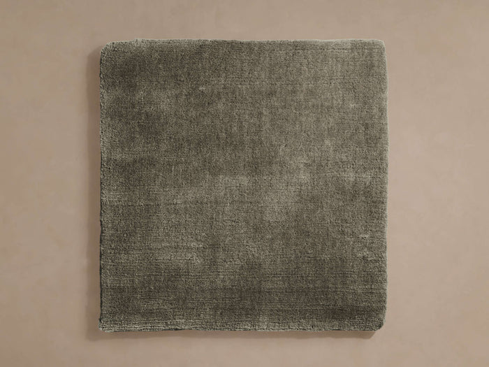 Muted olive green, square Salem Rug Swatch with a plush, textured surface, centered on a light beige background.