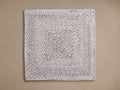 Sansa Outdoor Rug Swatch: A light grey and off-white rectangular braided rug swatch with dark flecks, seen from above.