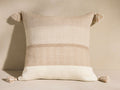 Savera Pillow: square, horizontally striped in beige, cream, and tan, with tassels on each corner.