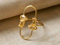 Sienna Citrine Ring: Gold-plated looped band with multiple oval & rectangular citrine stones, resting on textured beige fabric.