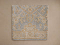 Sienna Hand-Knotted Rug with intricate blue and gold pattern, featuring geometric and floral designs, on a beige background.