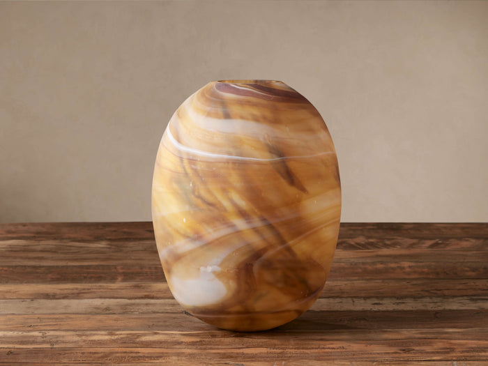 Strata Vase: Hand-blown oval glass vase with amber, brown, and white swirled patterns, sitting on a wooden surface.