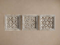 Set of 3 square, whitewashed Sukho Panels with intricate hand-carved designs, displayed horizontally on a beige wall.