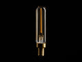 A tubular LED filament bulb with a clear glass casing and a brass base, illuminated against a black background.
