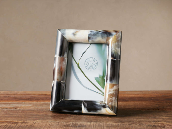 Upright Tabor Horn Frame made of polished, mosaic-like horn tiles in natural shades of brown, black, & white on wood.